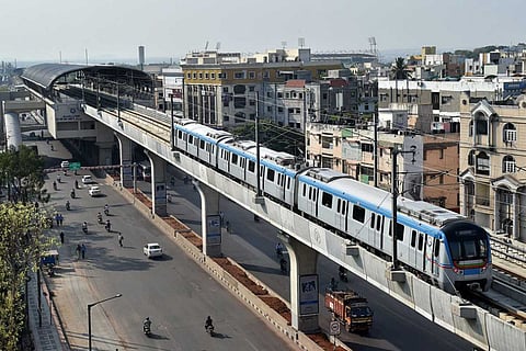 A Hyderabad metro train runs on an elevated railway line at Habsiguda in Hyderabad