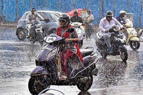 A woman rides her bike in the downpour