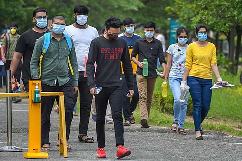 Students wearing masks walking up to a JEE test centre