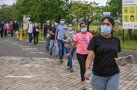 Students wearing masks walking up to a JEE test centre