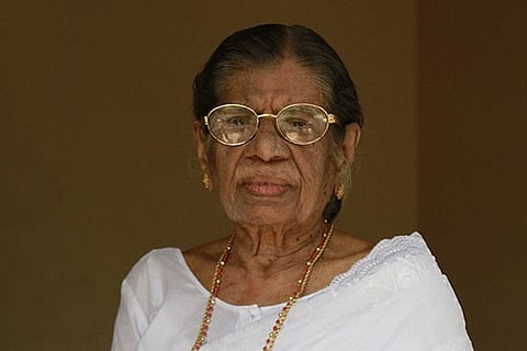 KR Gowri Amma in a white saree and spectacles 