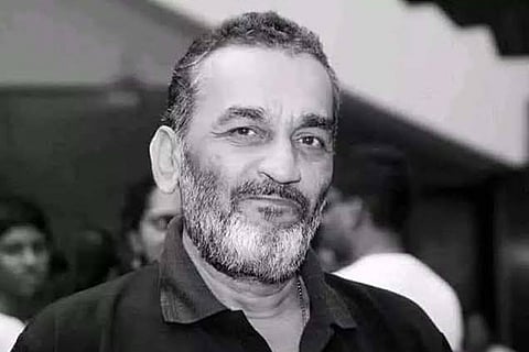 Monochrome image of Kannada film director KV Raju looking at the camera 