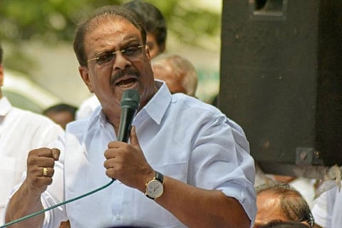 Kerala Congress Leader K Sudhakaran holding a mike speaking at a meeting 