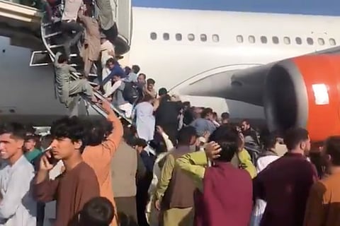 Afghan citizens scrambling to get onto an aircraft at Kabul airport