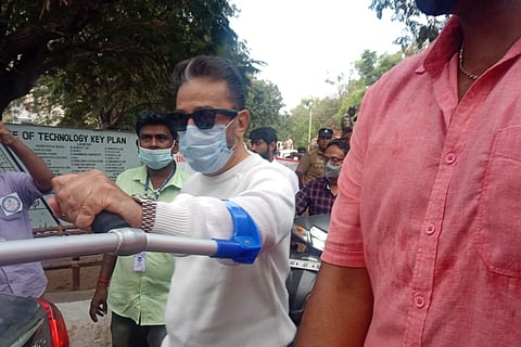 Kamal Haasan raises a walking stick against a reporter (not in the frame) in Coimbatore