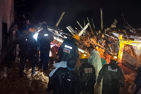 Fire and rescue officials clearing the debris following the landslide in Dakhina Kannada