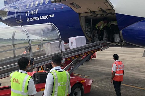Airports staff members ansporting vaccine shipments from an  aircraft 