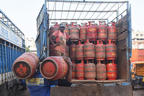 Workers unloading LPG cylinders from a truck