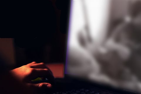 A person's fingers typing on a laptop