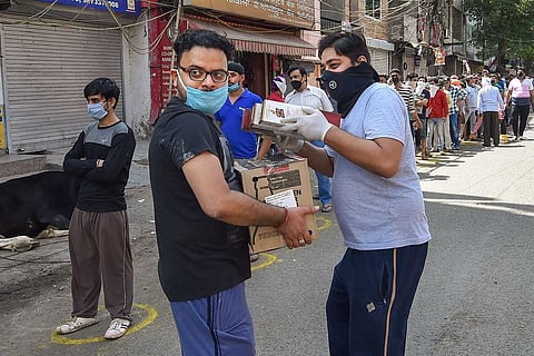 Customers buy liquor at a store in India after lockdown restrictions are eased