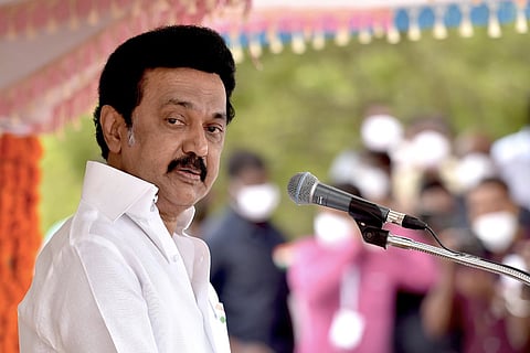 TN CM Stalin wearing a white shirt and seeing sideways for a picture 