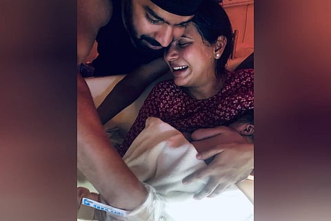 Mahat and Prachi are seen holding their newborn baby