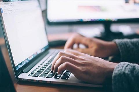 A person tying on their laptop