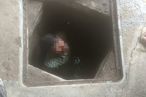 Blurred image of a worker inside a septic tank