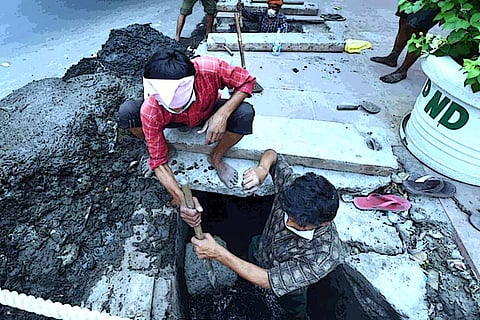 Two men involved in manual scavenging
