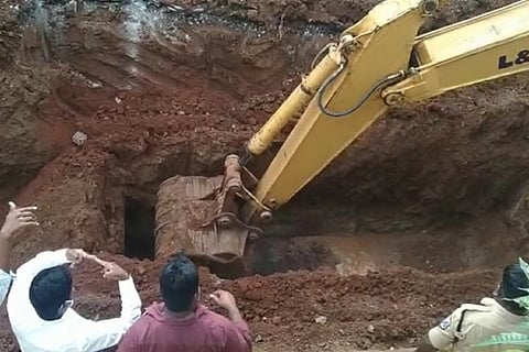 An earthmover digging in the manhole