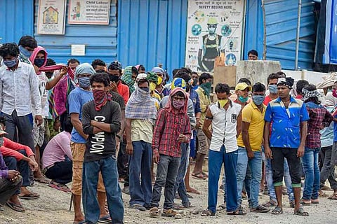 Migrant workers waiting along a roadside