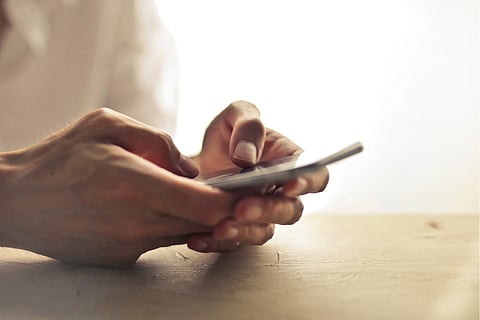 Representative image of a person holding a mobile phone in their hands