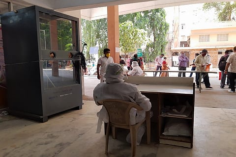 NIMS outpatient screening counter manned by two lab technicians 