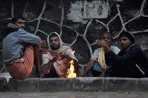 People sit around a bonfire