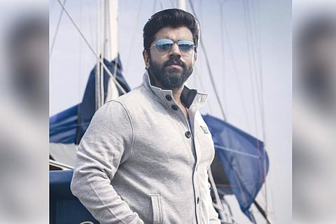 Actor Nivin Pauly is seen wearing a light coloured shirt and shades.