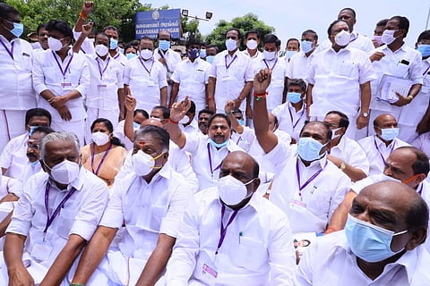 OPS and other AIADMK leaders sitting on the road wearing white 