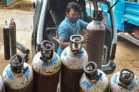 Bengaluru: Workers sort medical oxygen cylinders meant for Covid-19 patients, before dispatching them to hospitals, amid surge in coronavirus cases, at BMTC bus stand in Bengaluru
