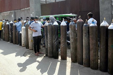 People lined up with oxygen cylinders for refilling