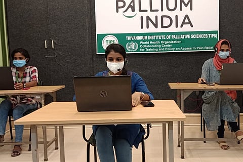 Three trained online counsellors are seen working on the laptops at the office of Pallium India NGO in Kerala. 