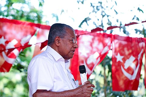 Kerala CM Pinarayi Vijayan with red flags in the background 
