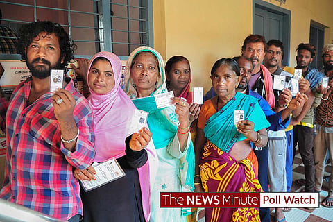 Image of voters standing in line at a polling booth. 