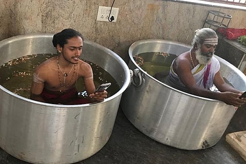 To appease rain gods, Bengaluru priests sit in water-filled vessels with phones