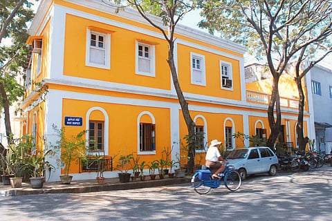 A yellow building with white windows in Puducherry