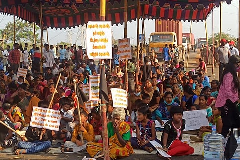 Villagers of Kattupalli Kuppam hold placards demanding permanent jobs 