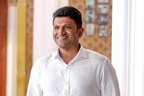 Puneeth Rajkumar wearing a white shirt and smiling