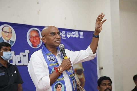 RS Praveen addressing a gathering with a BSP shawl around his neck