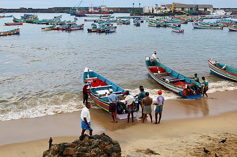 Fisherfolk near fishing boats preparing to venture into the sea 