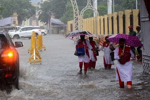 People walking with umbrellas in heavy rain
