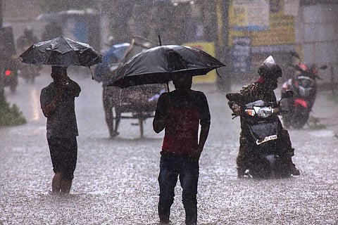 People walking with umbrellas in heavy rain