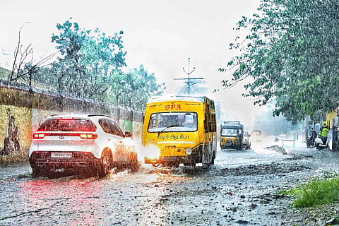 A school bus carrying children wades through a waterlogged road in Tamil Nadu