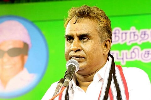 Profile of SP Velumani wearing an AIADMK scarf as he speaks into a mic