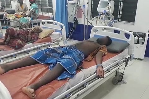 Sakthivel seen lying on a hospital bed with his left wrist handcuffed to the bed