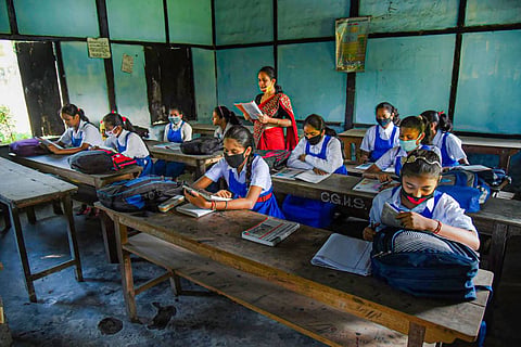 Girl students with mask studying in classroom