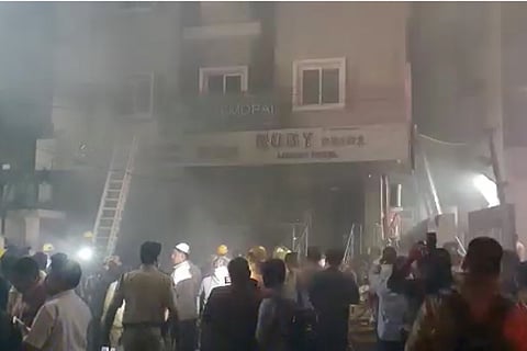 People standing outside Ruby Pride lodge in Secunderabad where eight people were killed in a fire
