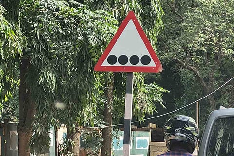 A signboard with four dots on white background.