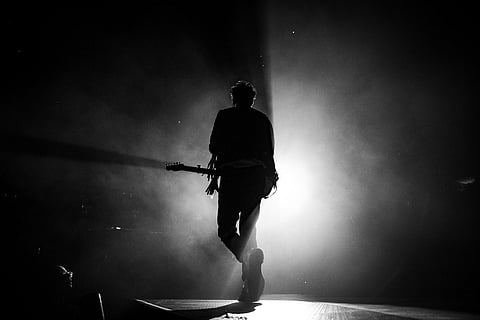 A person with a guitar on stage 