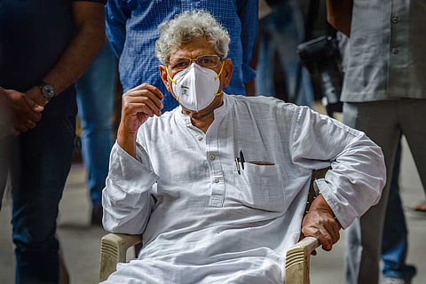 Sitaram Yechury wearing a mask and sitting