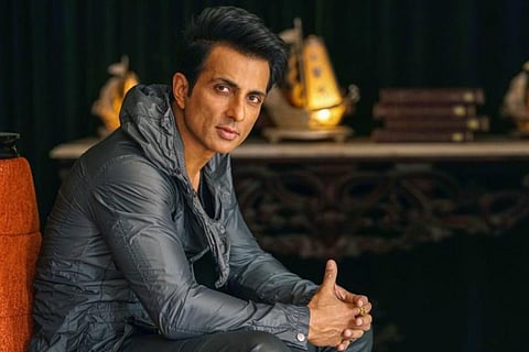 Sonu Sood is seen in a shiny grey tee in the image.