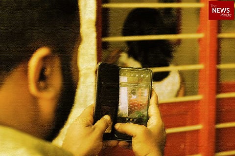 Representative image of a man stalking a woman and recording her without consent