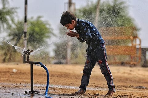 A boy cooling himself with water